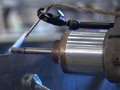Close up image of the drill bit-like rotating tool on a friction-stir welding machine.