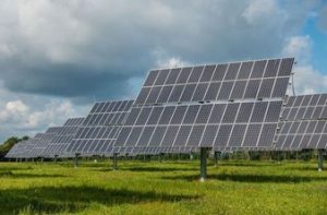 Photograph of mounted solar panels in a field of green grass.
