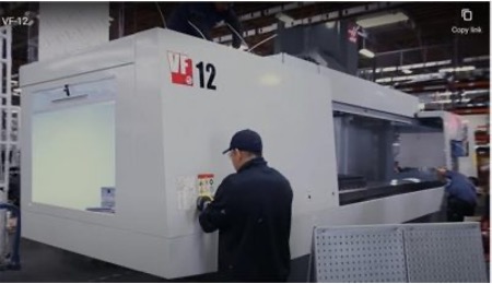 A Taber operator using the cutting edge Taber machine called Haas VF-12 CNC machine inside the Taber facility.