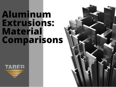 Aligned on the left is the blog title, “Aluminum Extrusions: Material Comparisons,” which is written in bold black font with a dark and light grey transparent background and the Taber logo beneath it. On the right, are a bunch of aluminum pieces that are unevenly, yet elegantly stacked vertically, showcasing different shaped profiles on a clear white background.