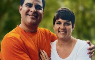 Taber Extrusions' David Jackson, a man in an orange shirt with arms around Trina, a short-haired woman in white shirt