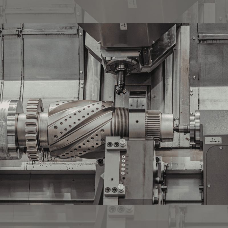 Taber-2026-06-large-intricate-metal-par A large intricate metal part being precisely machined on an industrial lathe, demonstrating in-house aluminum extrusion machining services.